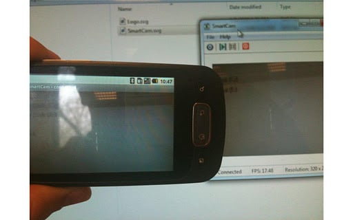 Smartphone tenu à la main avec l'application de webcam en cours d'exécution