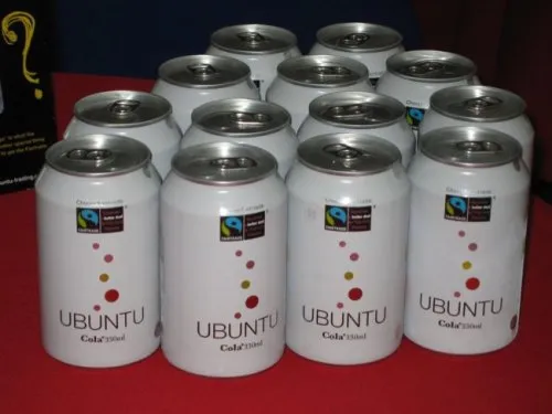 Personne buvant du Ubuntu Cola devant un ordinateur avec des stickers Ubuntu