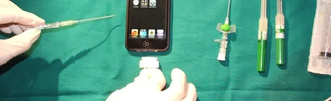 iPod Touch sur la table d'opération avec des instruments médicaux en arrière-plan