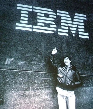 Steve Jobs, fondateur d'Apple, posant devant un ordinateur Macintosh